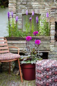 Una sedia e un vaso con fiori viola